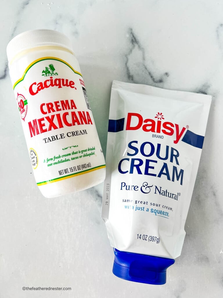 Bottle of crema Mexicana and container of sour cream, side by side.