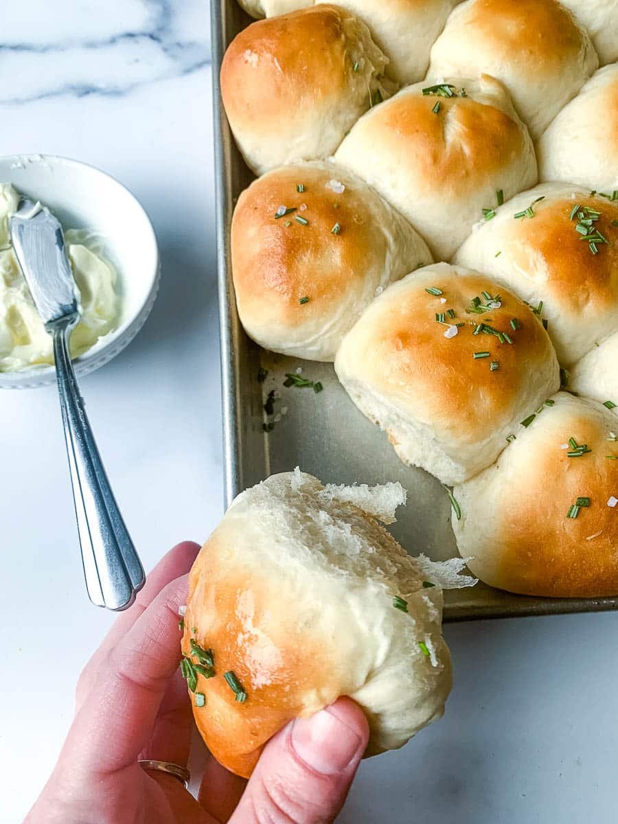 Soft and fluffy homemade yeast rolls on a baking pan.