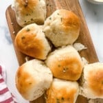 Old fashioned dinner rolls on a bread serving board.