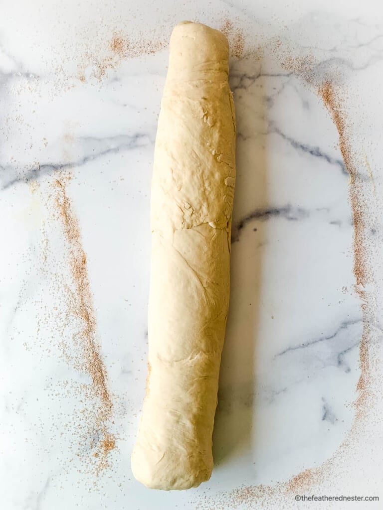 A large piece of sweet yeast dough on a marble countertop
