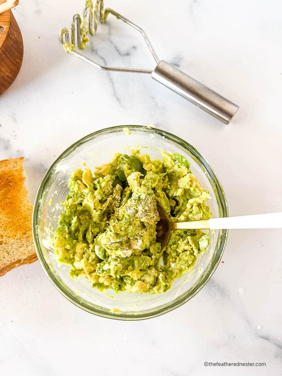 bowl of mashed avocados with seasonings.