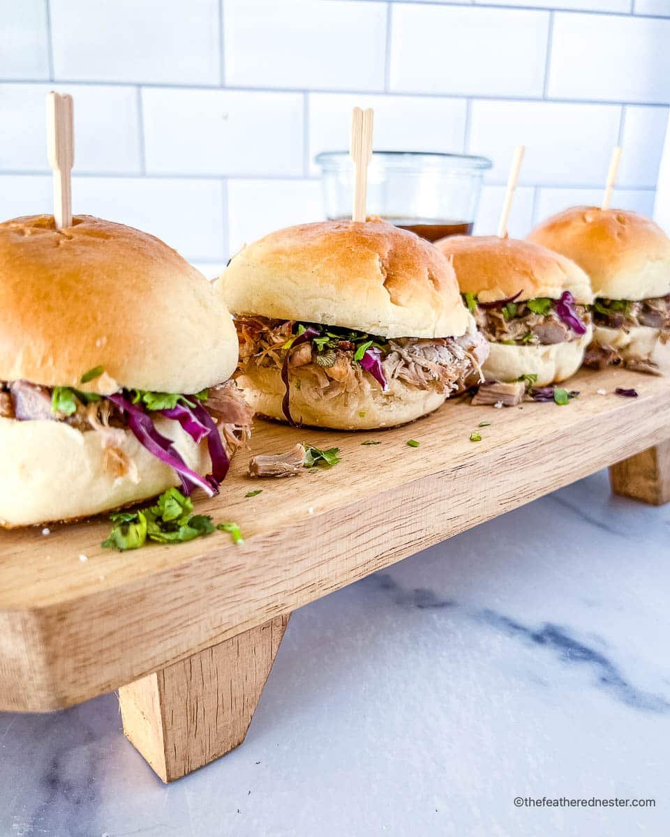 Dutch oven pulled pork sliders, topped with slaw and ready for serving.