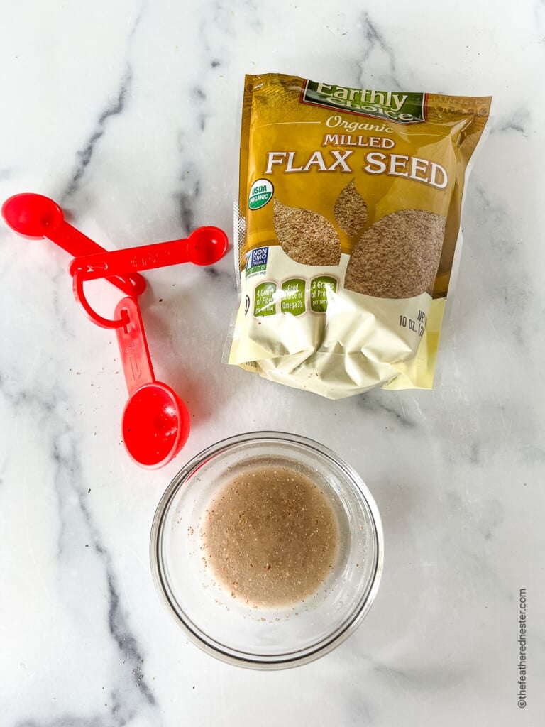 Flax egg substitute for cornbread in a small glass bowl. Package of flax seed next to it.