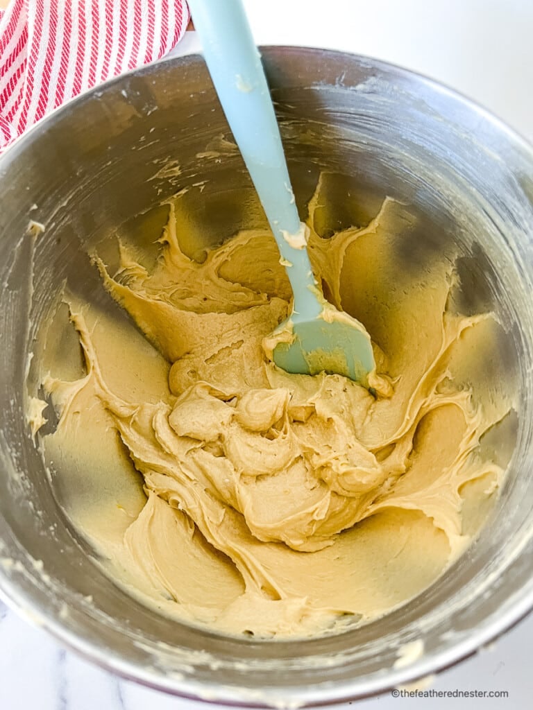 Mixing spatula in a mixing bowl with peach cobbler cake batter.