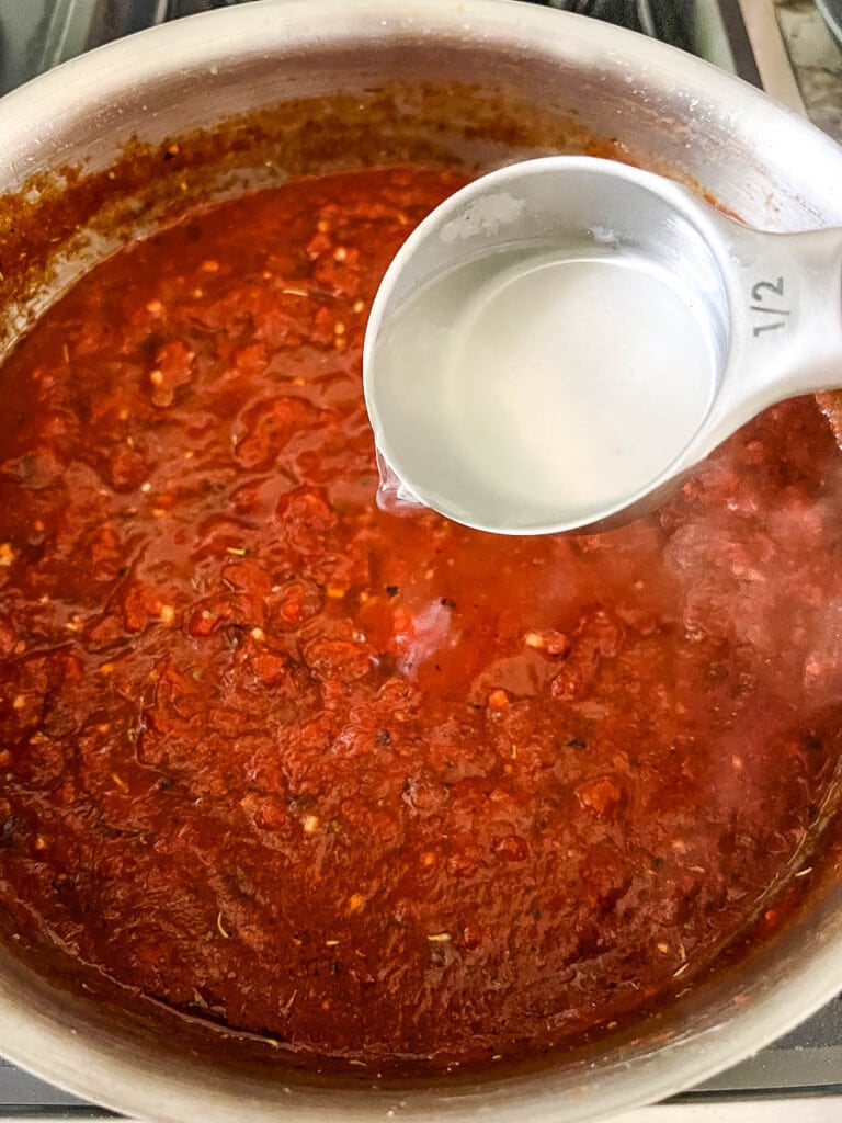 Thinning sauce for a tomato basil pasta recipe with starchy pasta cooking water.