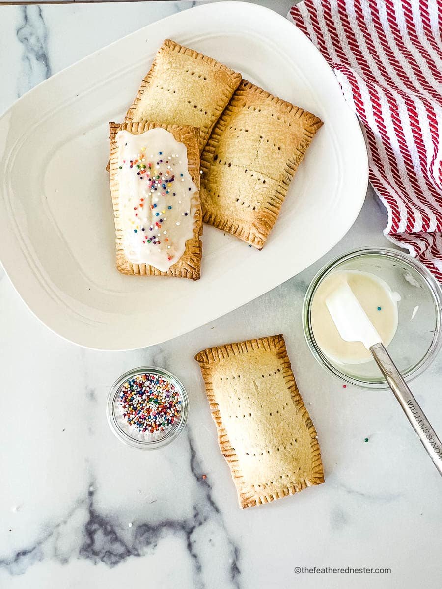 Frosting blueberry pop tarts with icing.
