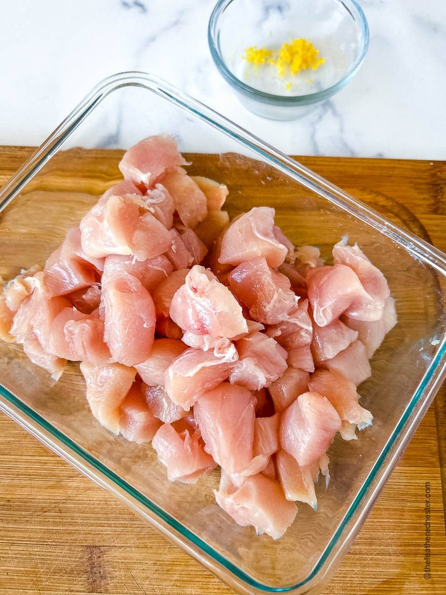 uncooked chicken nuggets in a glass baking dish.