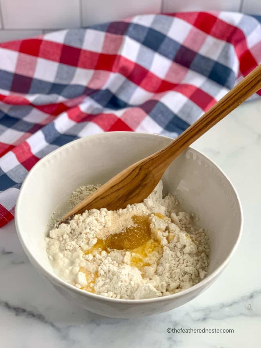 Wooden spoon in bowl of biscuit batter for a Bisquick dessert.