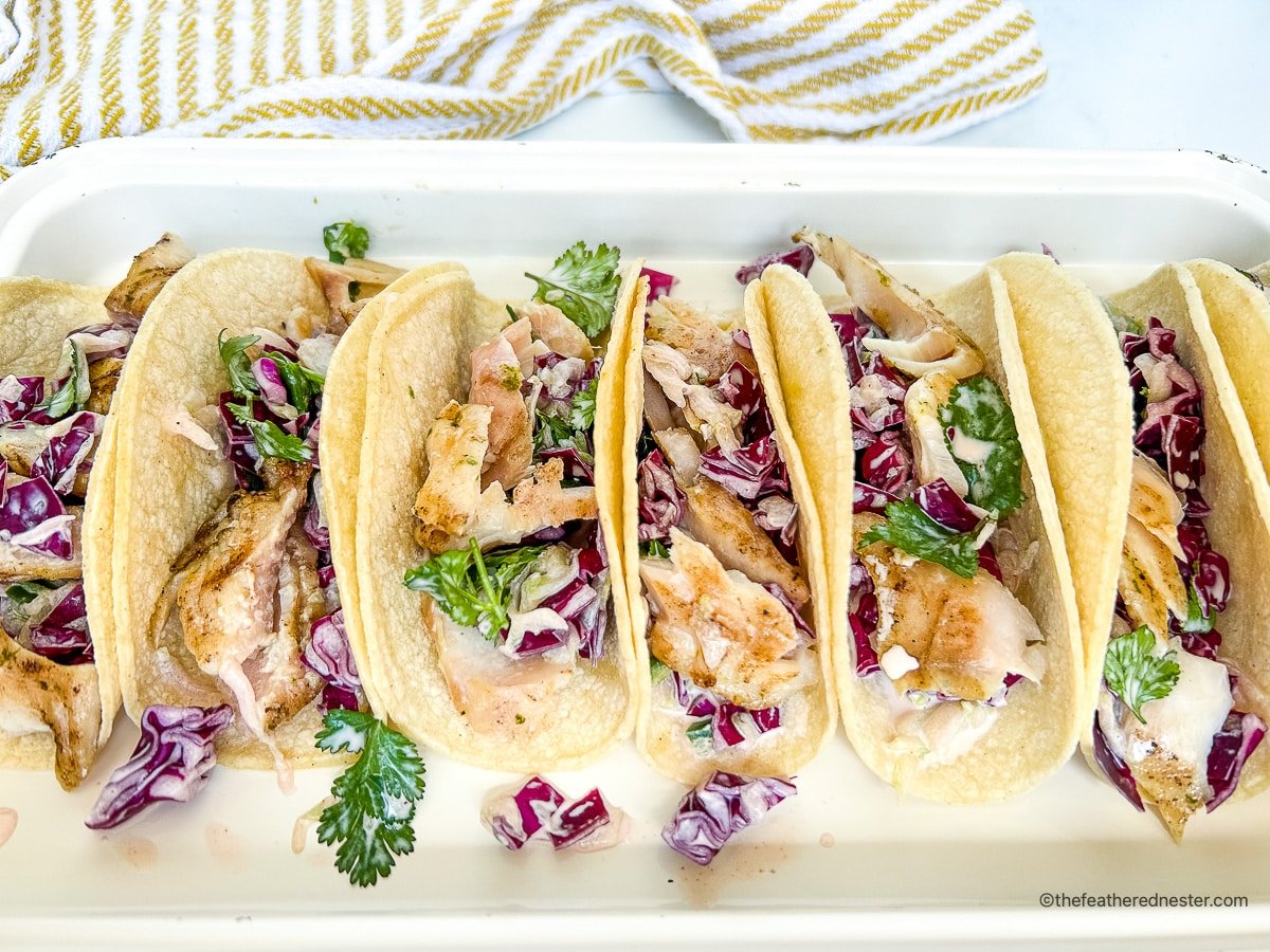 Hawaiian rock cod and cucumber slaw inside of soft corn tortillas.