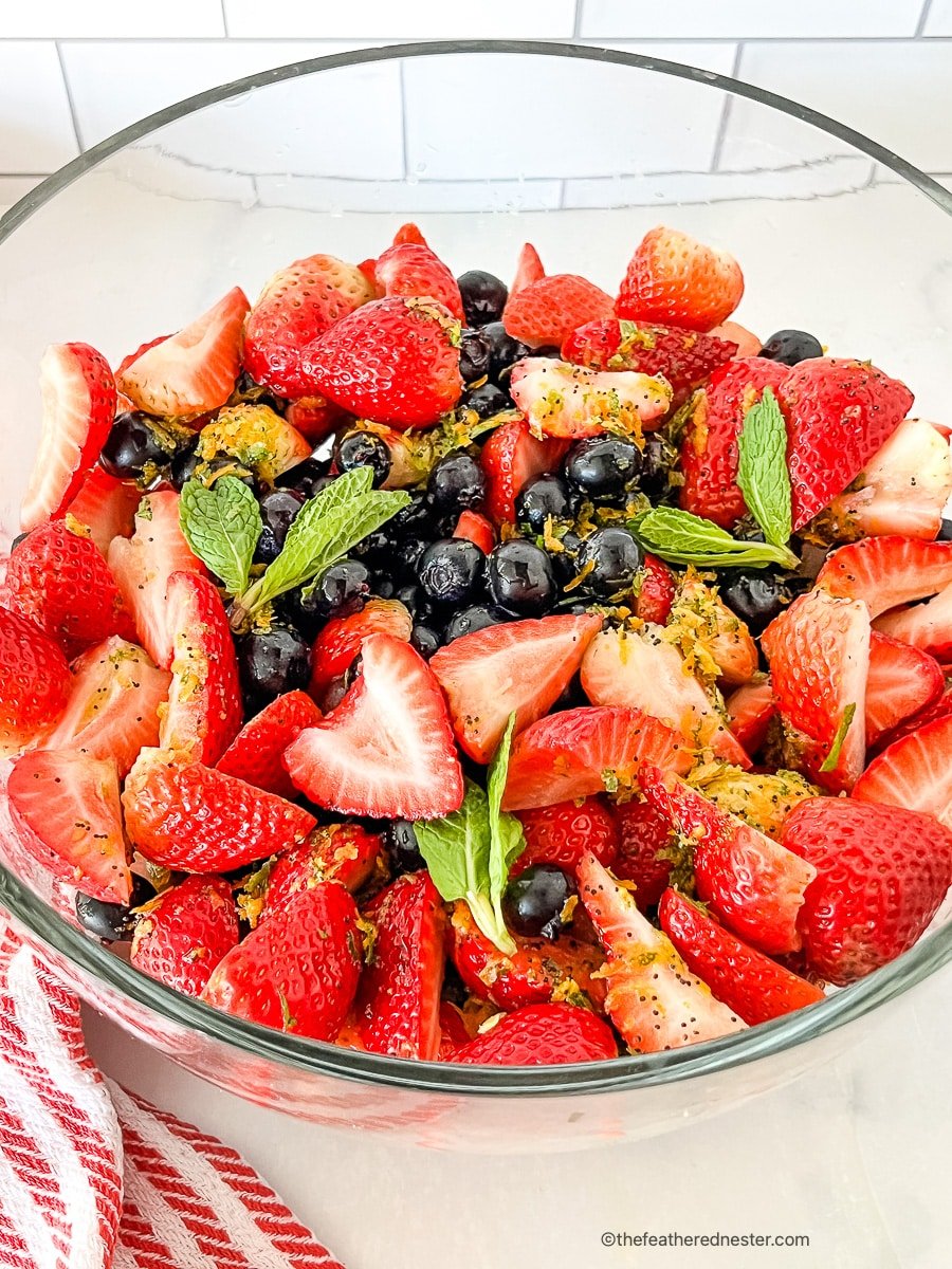 Glass bowl filled with strawberry blueberry salad.
