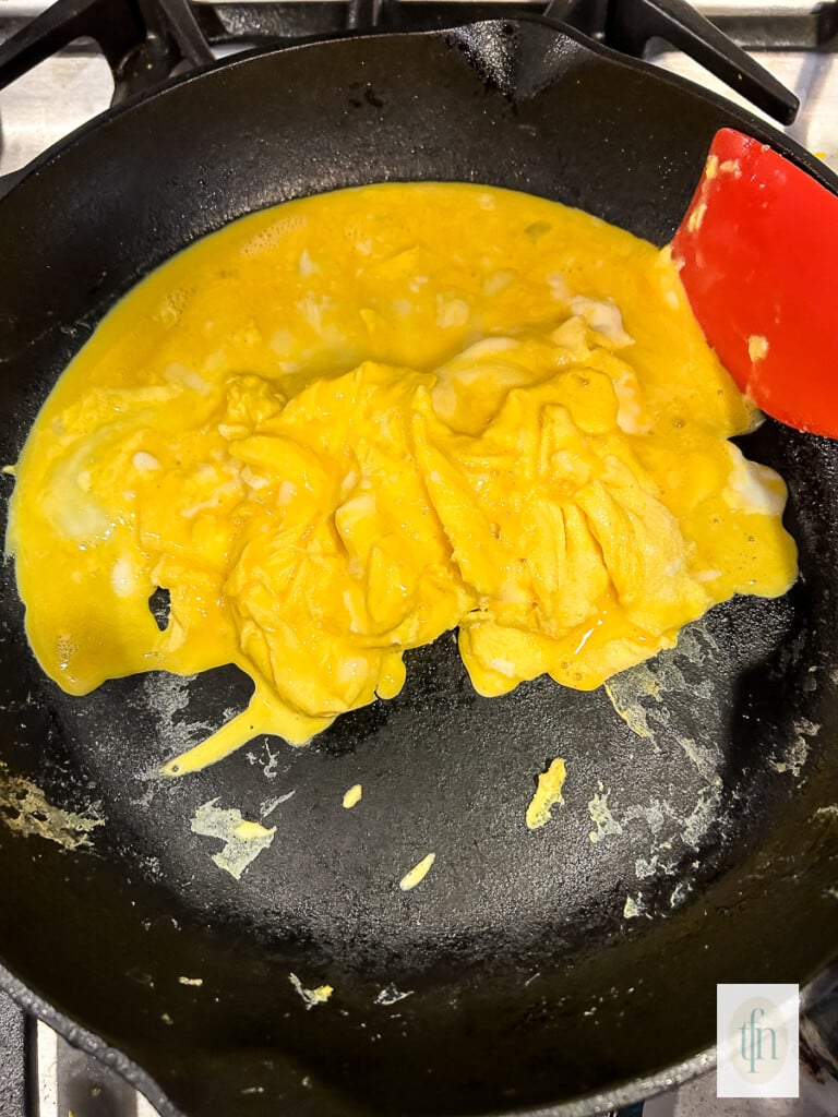 Fluffy scrambled eggs in a non-stick skillet.