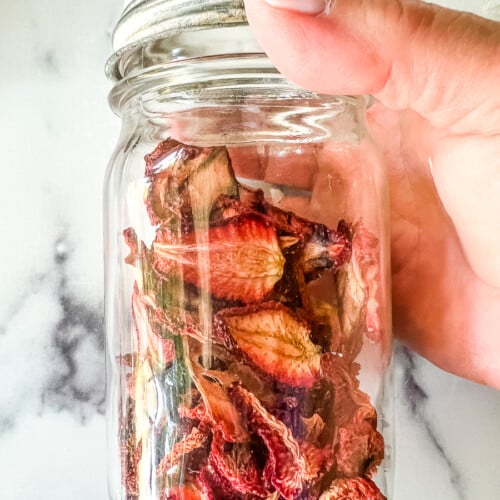 Dehydrated strawberries in a small glass jar.