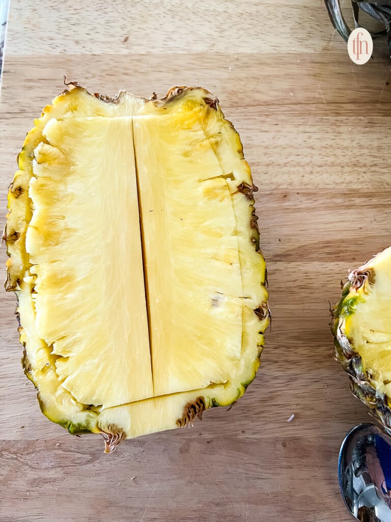 One half of a large yellow fruit, with knife cuts made through the core
