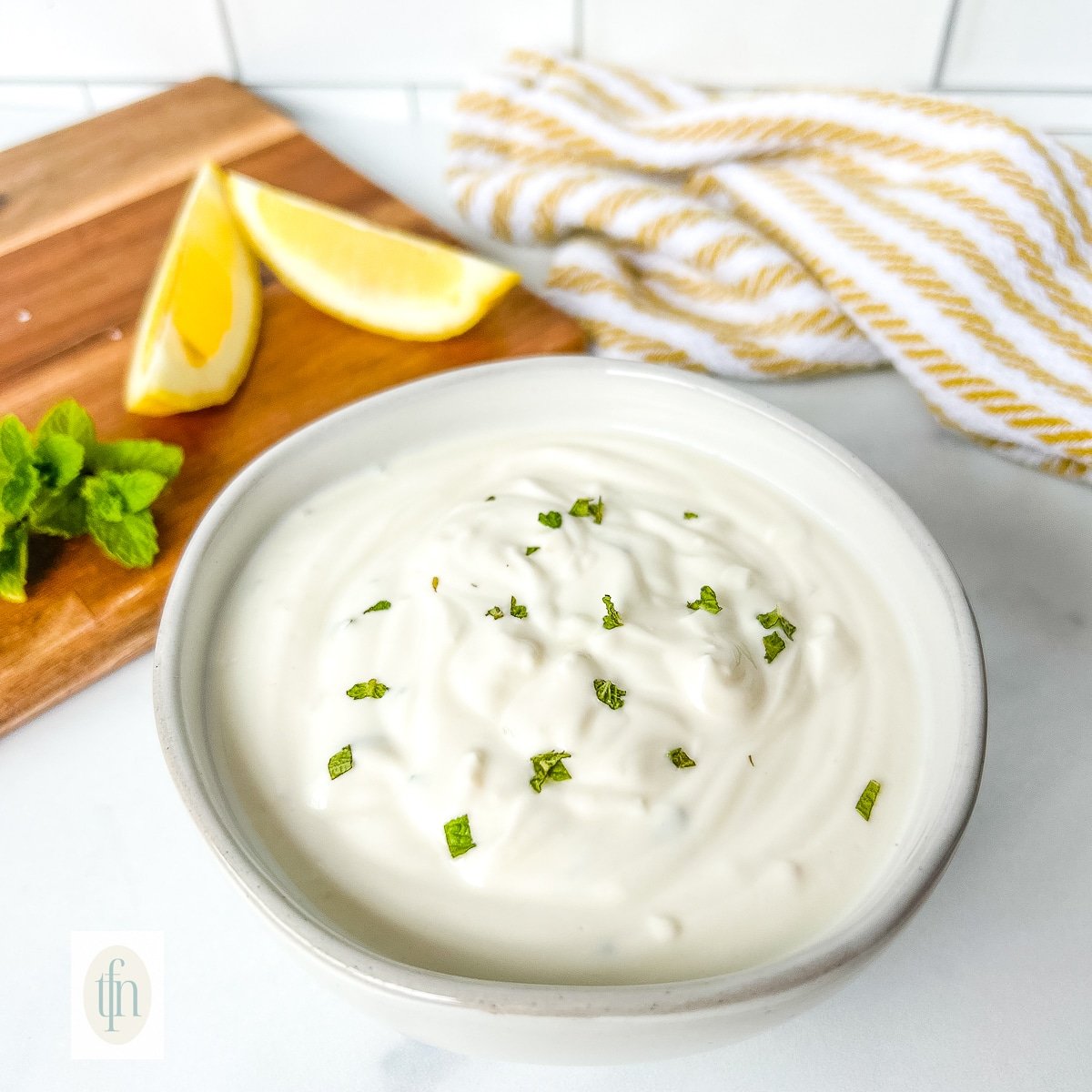Yogurt dipping sauce in a small white bowl.