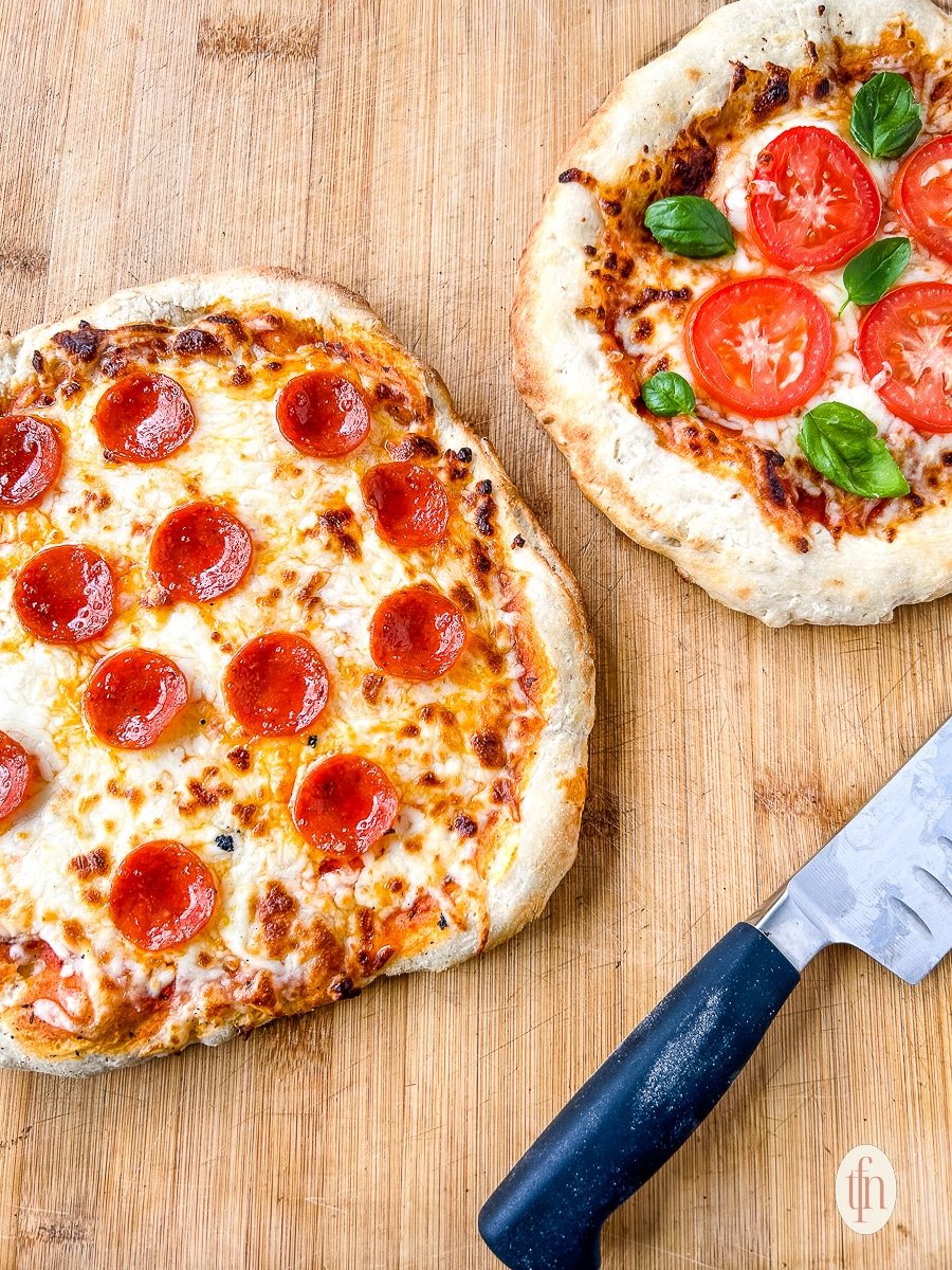 Two beautifully golden, perfectly baked pizza dough with sourdough discard made with sourdough starter.