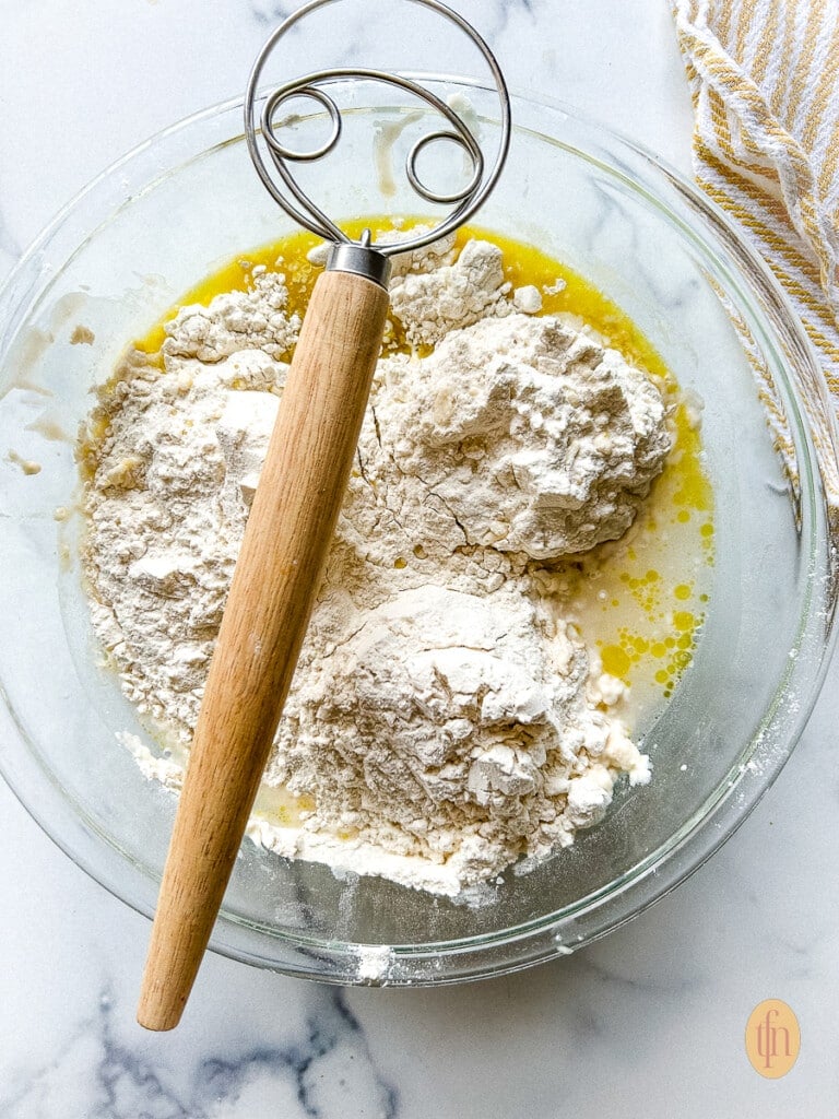 Flour, water, and active sourdough discard combined in a bowl for sourdough pizza crust recipe.