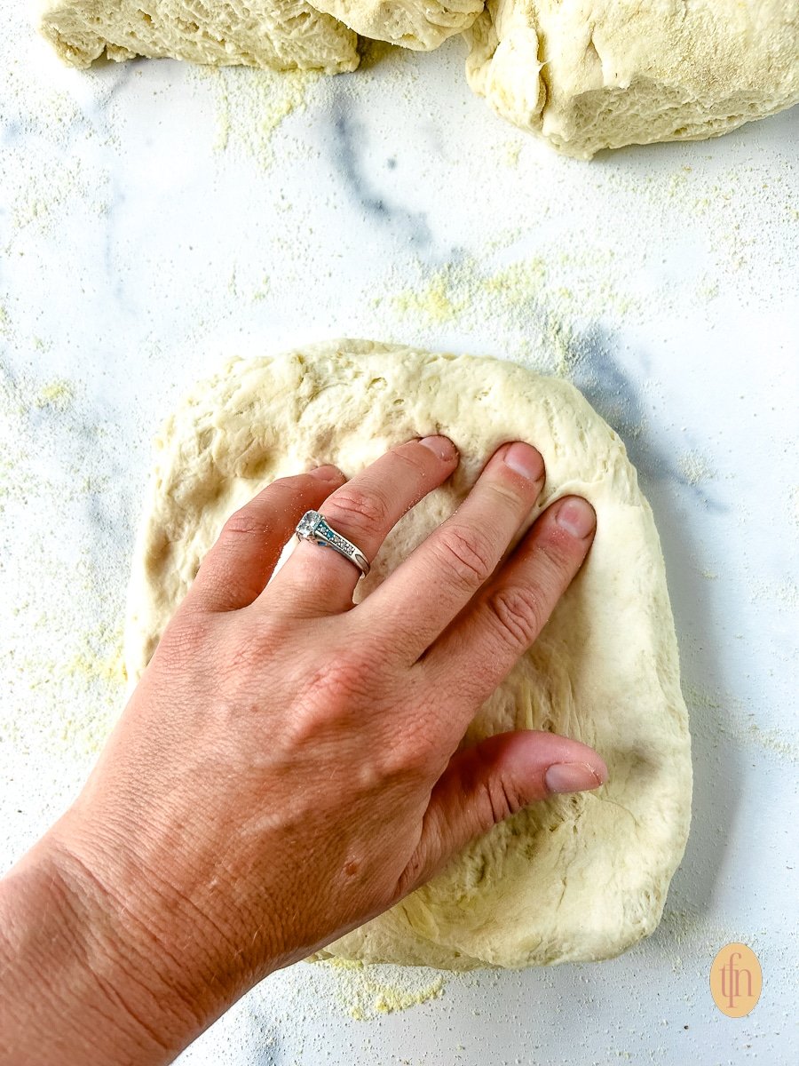 Woman pushing her fingertips into an unbaked crust.