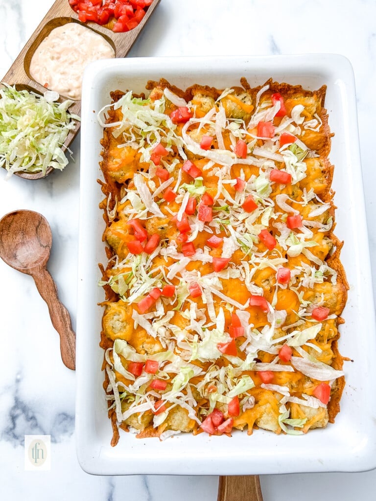 Cheeseburger tater tot casserole in a white baking dish, ready to serve.