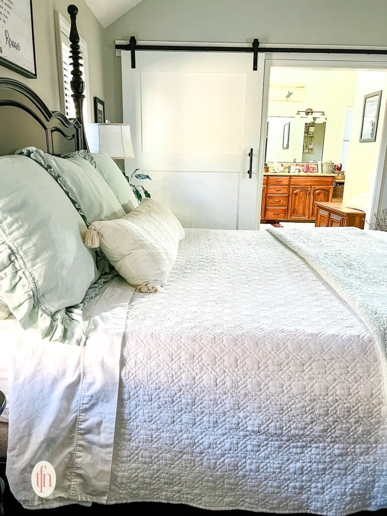Side view: beautiful layers of bedding with shams and pillows on top.
