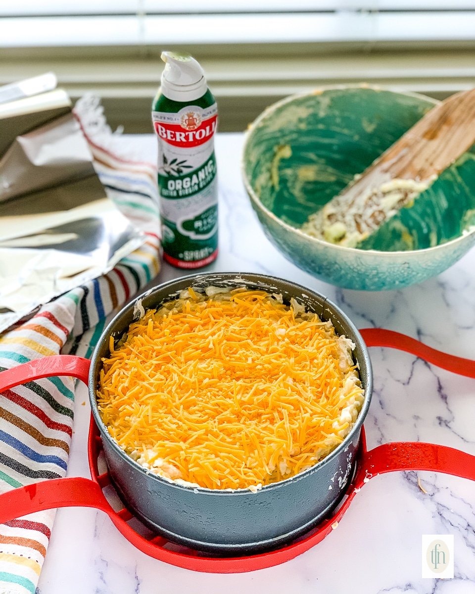 Shredded cheddar cheese on top of an unbaked casserole.