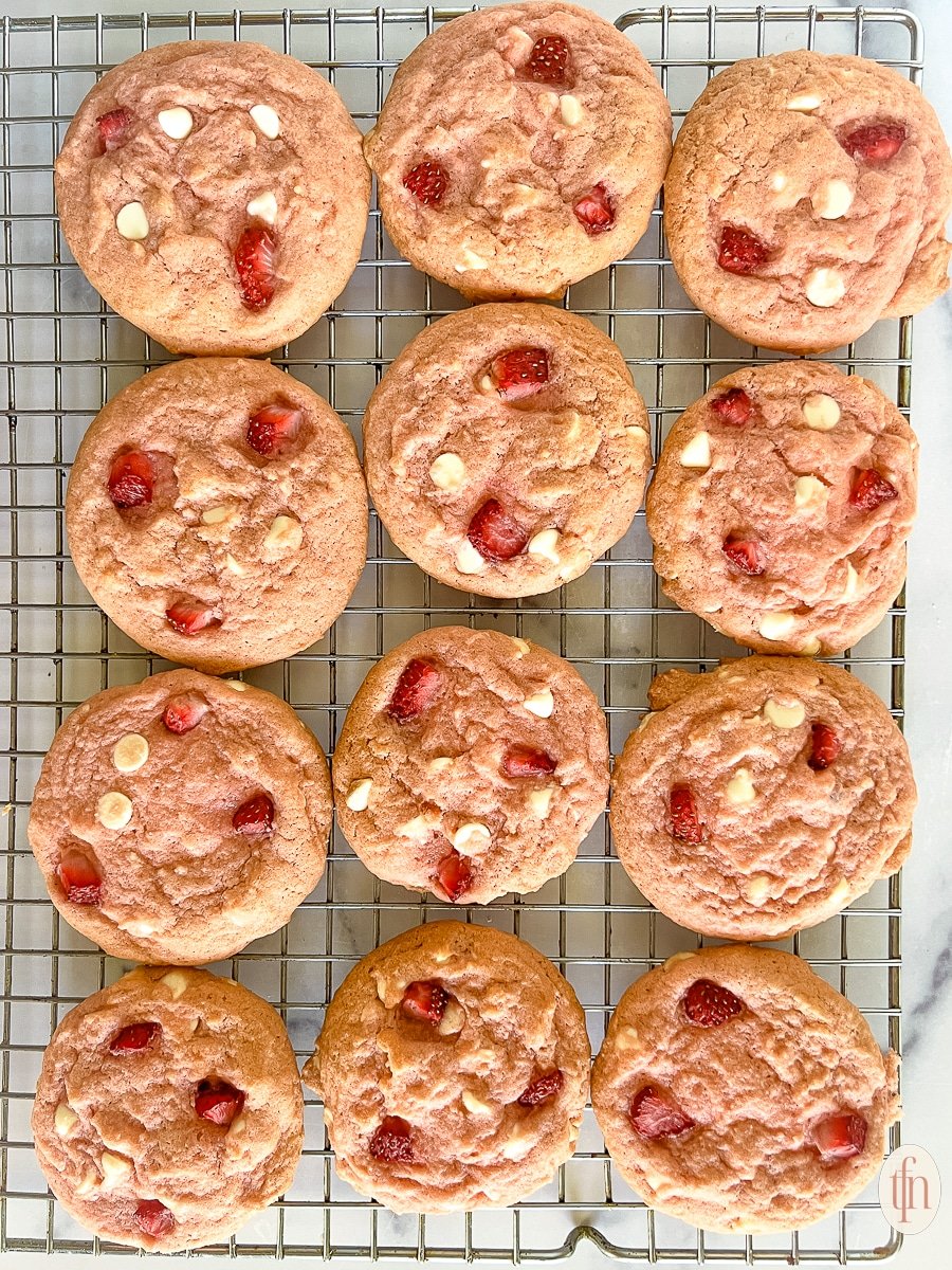 Strawberry cookies on a metal cooling rack.