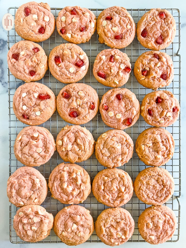 Cooling rack of baked strawberry cheesecake cookies.