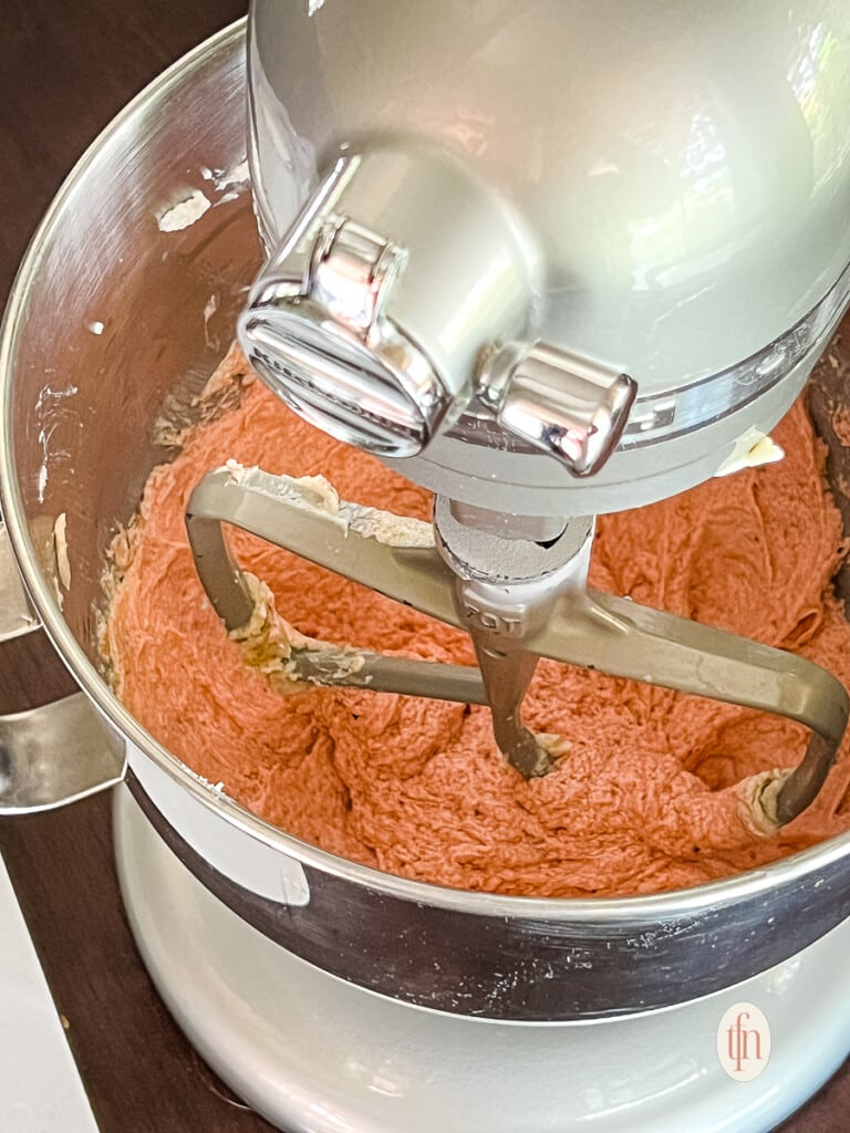 Making a strawberry cookie recipe in the bowl of a KitchenAid stand mixer.