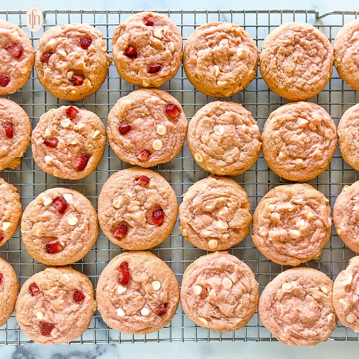 Baked strawberry cookies on a cooling rack.