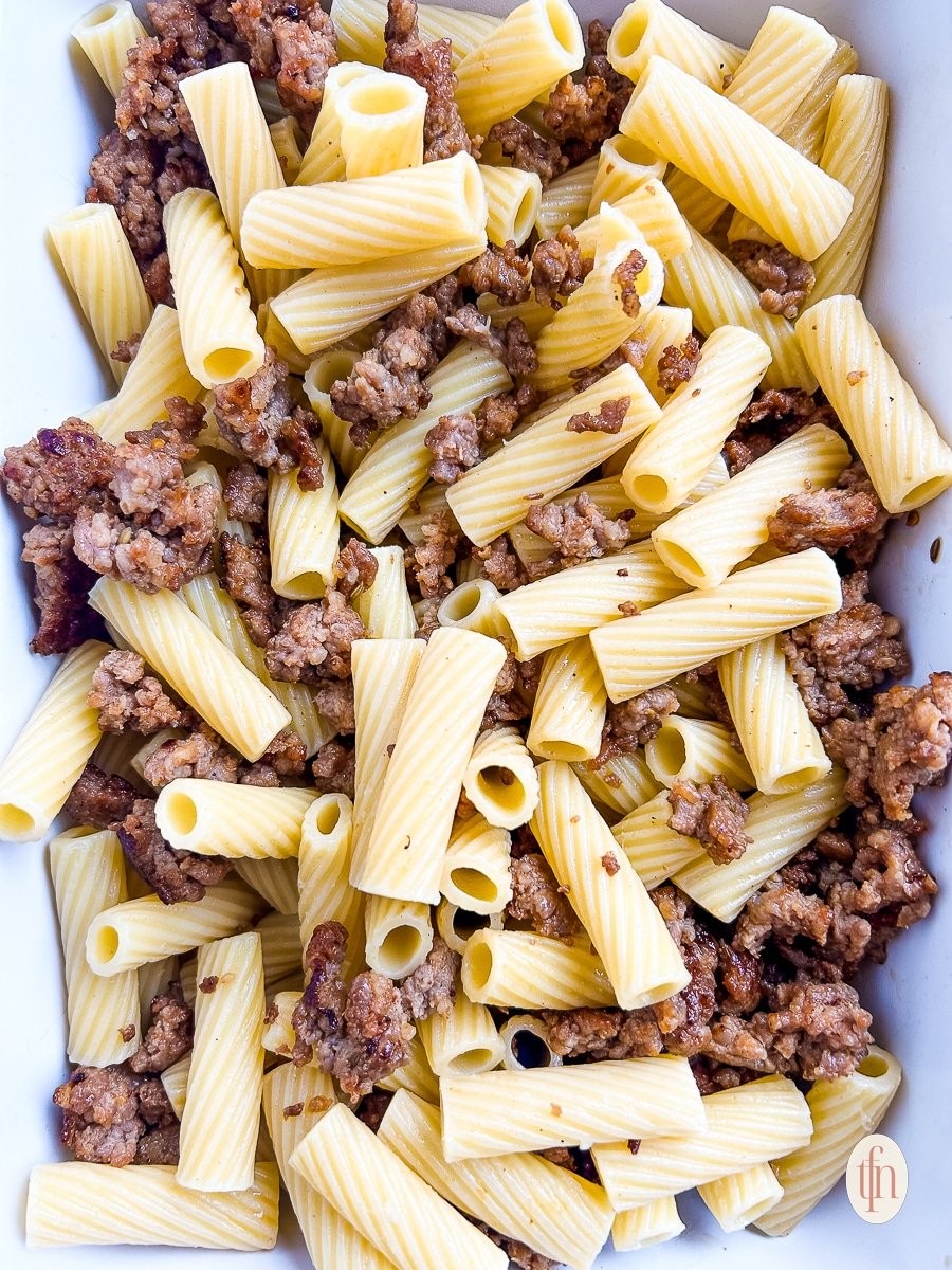 Cooked noodles and meat in a casserole dish.
