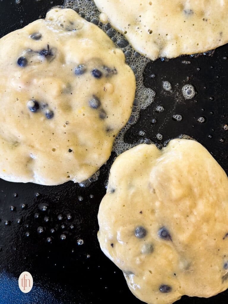 Making panackes with muffin mix on a hot griddle.