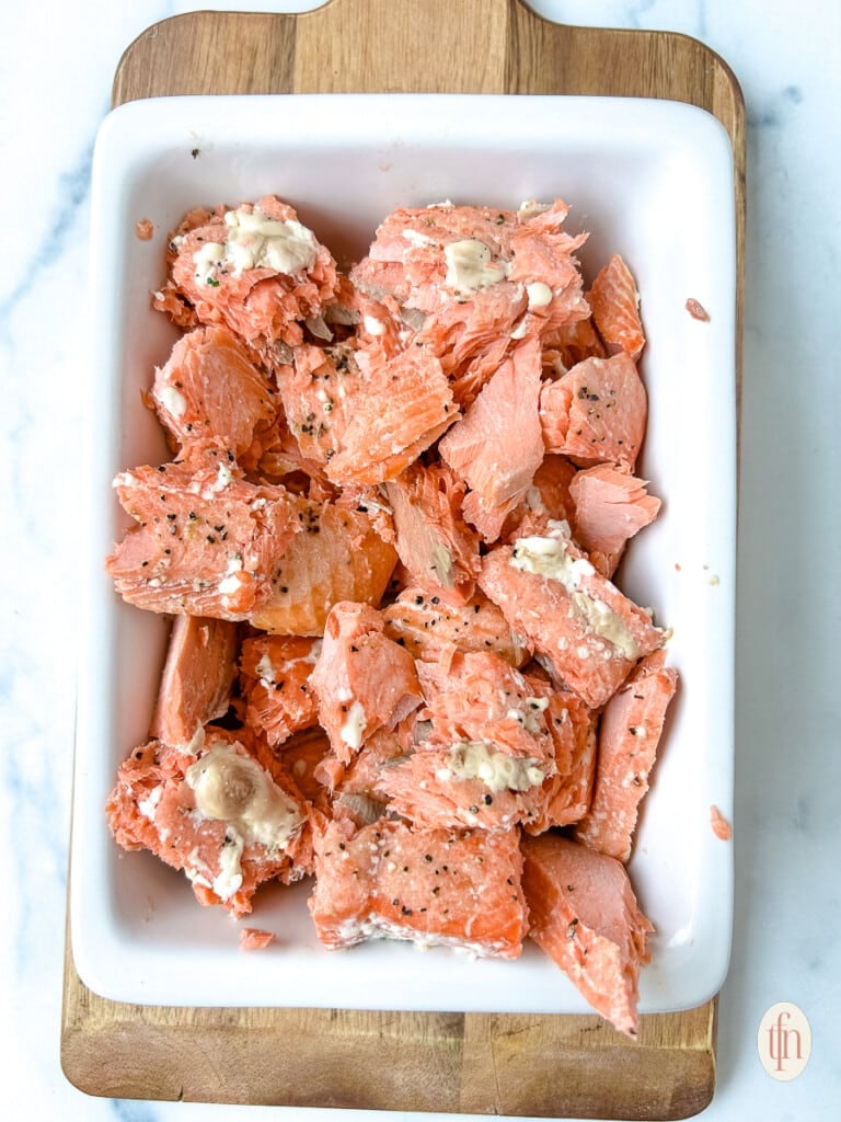 Pieces of baked Italian salmon in a serving dish.