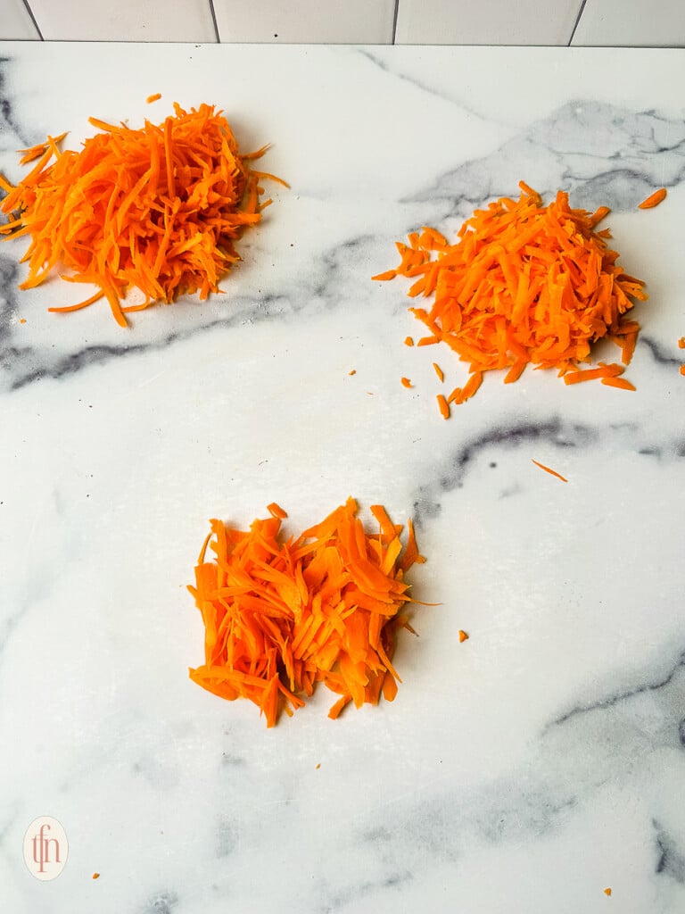 Shows three ways of shredding carrots: with a box grater, in a food processor, and with a vegetable peeler.