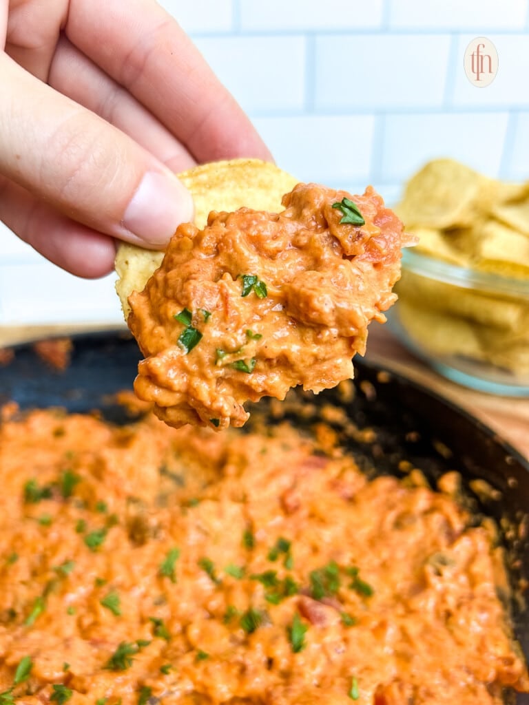 Chip covered in smoked queso dip, shown close up.