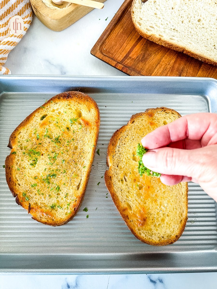 Sprinkling parsley over the tops of toasted garlic bread.