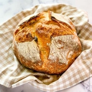 Baked bread round on a plaid napkin.