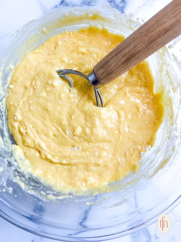 Apple cobbler batter mixed in a glass bowl.