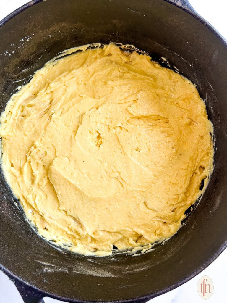 Cake mix covered apple slices right before baking in a cast iron pan. 