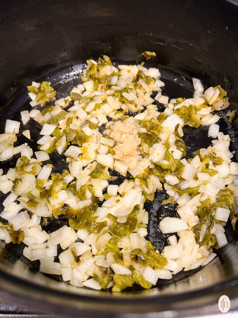 Ingredients sautéing in a pot on the stove. 