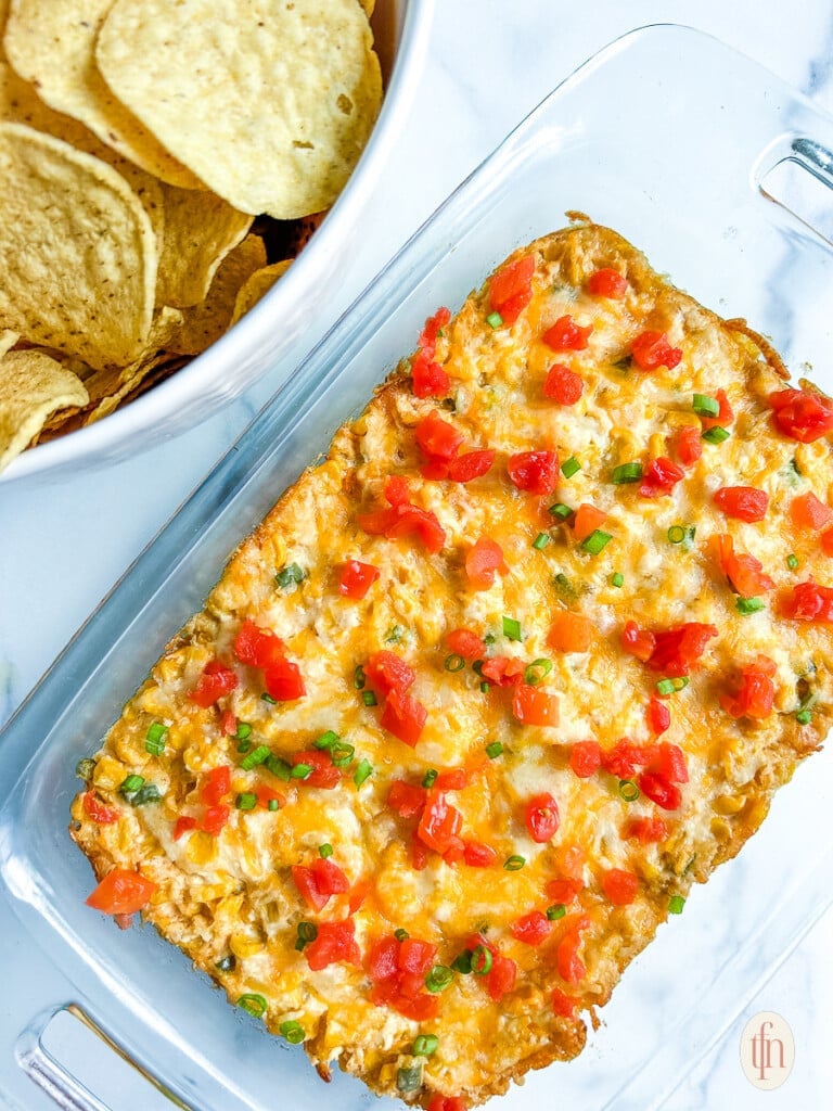 Serving dish with corn dip on a white background.