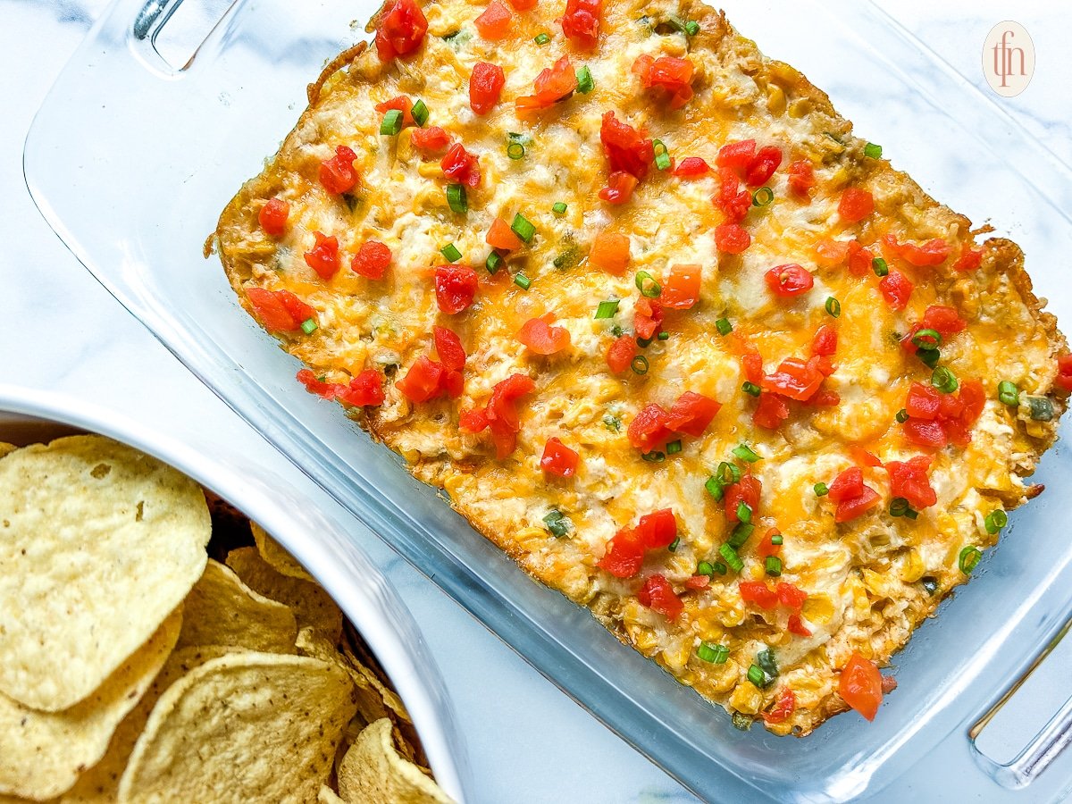 Serving dish with corn dip on a white background.
