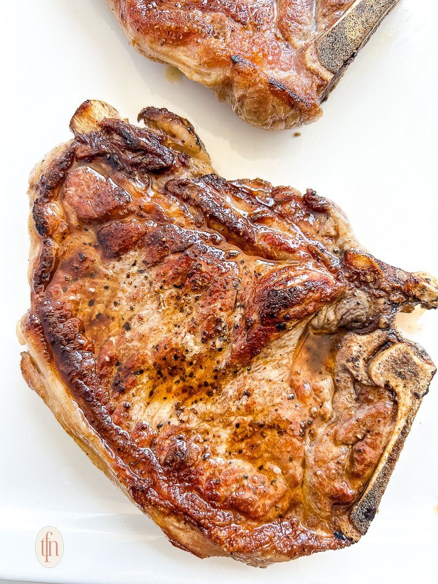 A perfectly seared shell steak (bone-in New York strip).