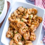 Blackstone hibachi shrimp on a white platter next to a bowl of white.