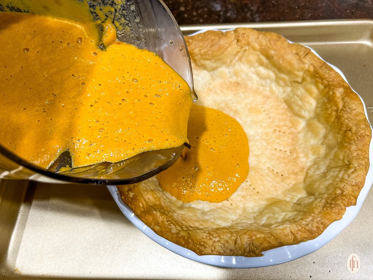 Pouring filling into a blind baked crust.