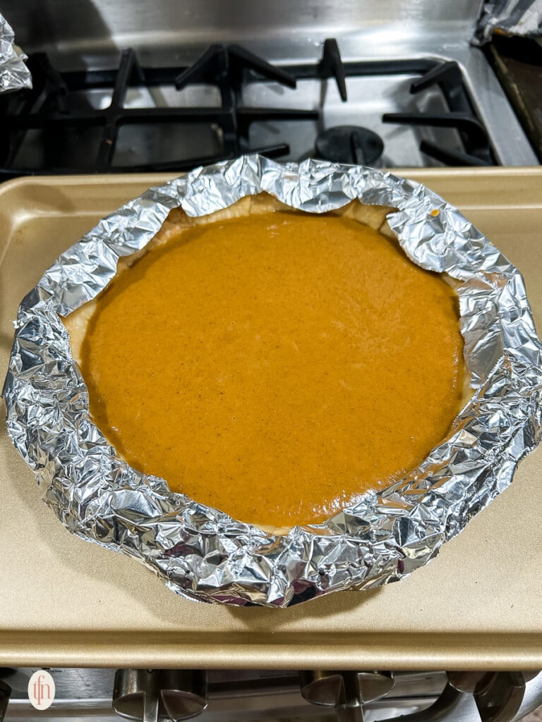 Pie ready to be baked with foil on the crust.