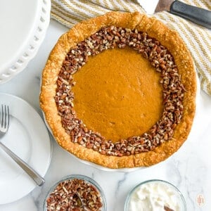 Baked pumpkin pie topped with chopped nuts.