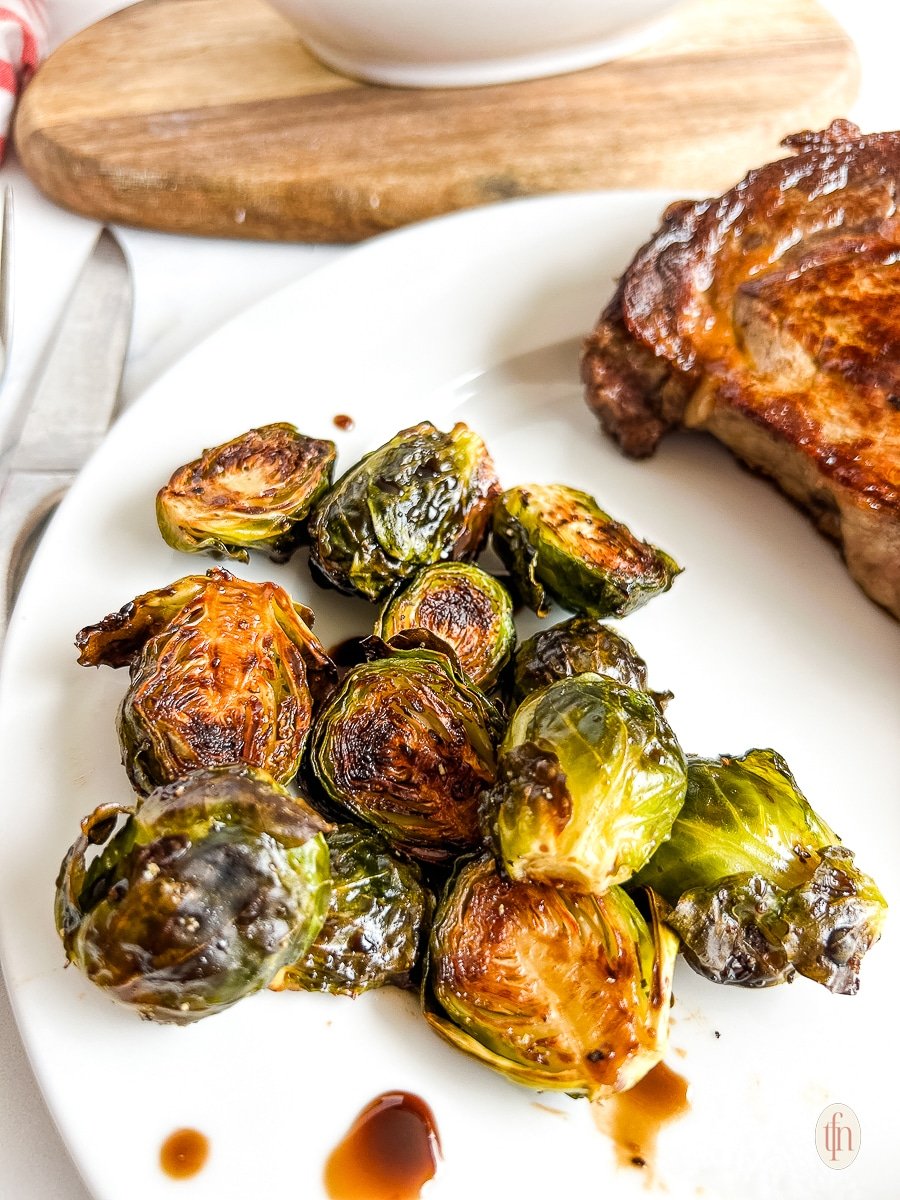 Maple balsamic brussel sprouts on a white plate.