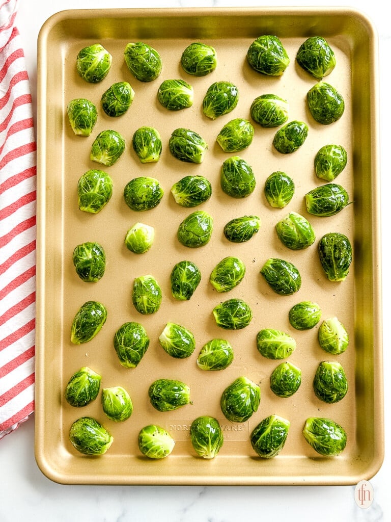 Sprouts cut side down on a baking sheet.