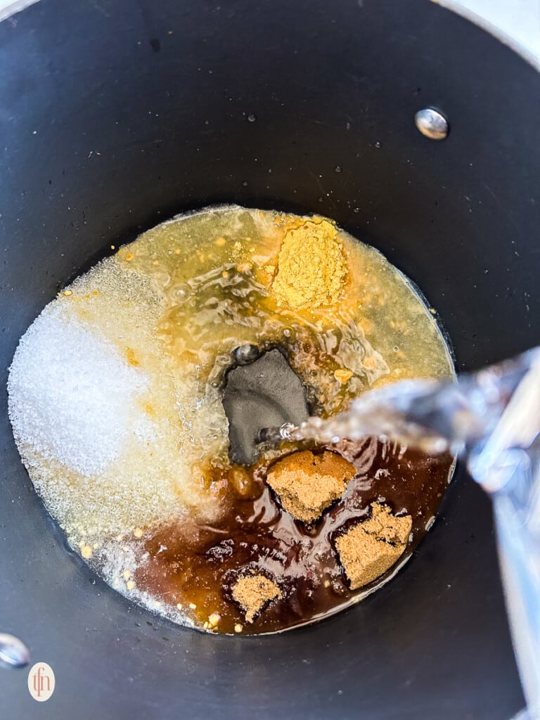 Pouring water in pot with spices for turkey brine.
