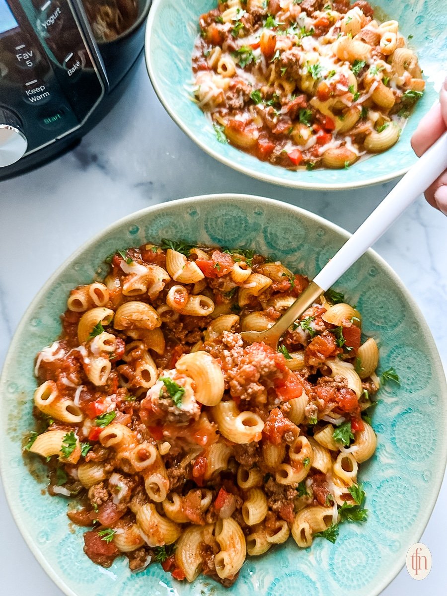 White-handled spoon in a bowl full of American goulash.