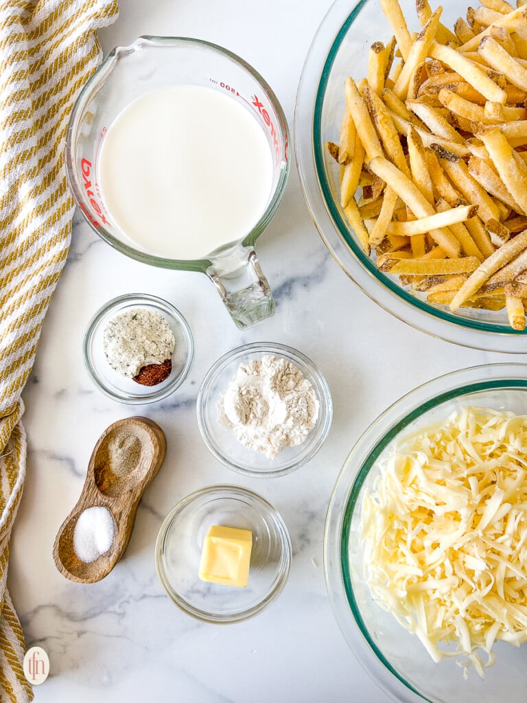 Ingredients for Louisiana Voodoo Fries in small glass bowls on a white background.